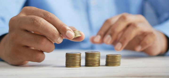 a person stacking coins on top of a table